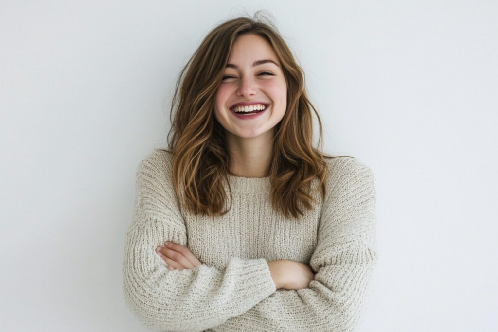 Ein lachendes Mädchen mit blondbraunen Haare hat lachend die Arme verschränkt. Sie freut sich über die neuen Produktinformationen.