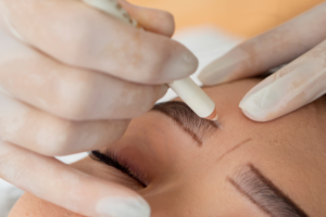 Eine Frau die Permanent Make up erhält in einem Kosmetikstudio. Sie hat zuvor alle Allergiehinweise erhalten. Und einen Pflegehinweis nach der Behandlung